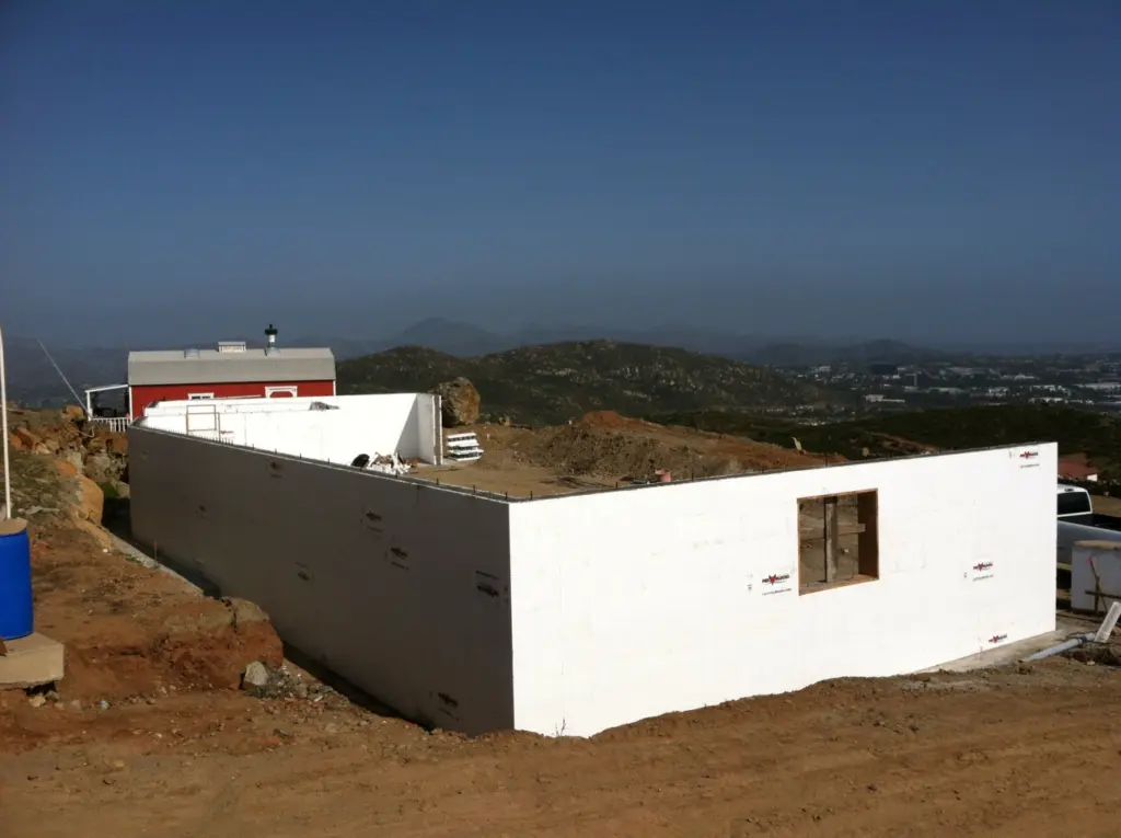ICF walls standing on a hilltop site with a valley view beyond